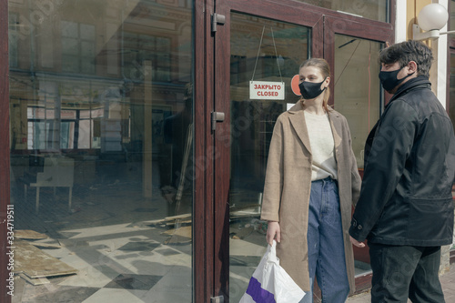 Portrait of couple in love in a surgical bandage on a background of a closed cafe