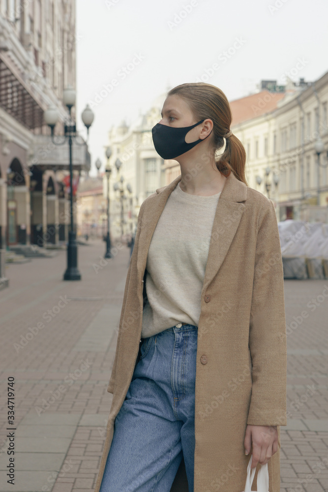 Young woman standing outdoors wearing medical mask to protect others from virus spread