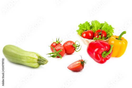 Ripe fresh organic vegetables in drops of dew isolated on a white background. Tomatoes, zucchini, bell peppers and lettuce isolated on a white background.