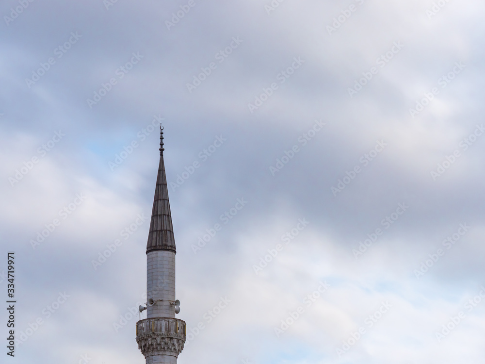Minaret of a Muslim mosque on the background of the cloudy sky. Minaret of a Muslim mosque on the background of the cloudy sky.