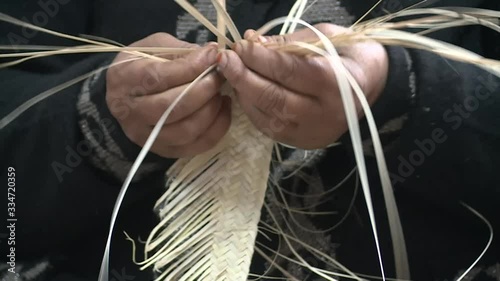 Hands starting an object out of palm leaves.Workshop of Tunisian arabic women weaving traditional goods from palm leaves.