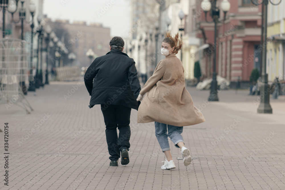 Man and woman running in medical masks, protection against the virus. Pandemic. Coronavirus.