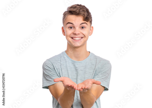 Portrait of cute smiling teen boy holding nothing. Happy teenager with empty palms up, isolated over white background. Child stretched out his hands - sign of begging or giving.