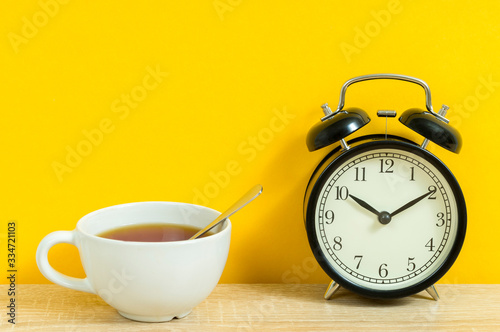 white tea mug and old alarm clock