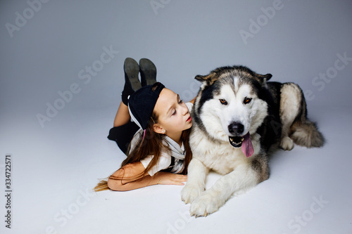 girl lying on the floor hugs and looks at the dog