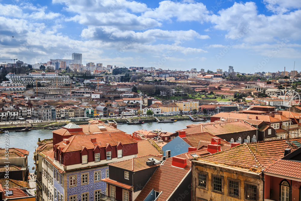 Sweeping view over the city of Porto, Portugal with the Douro River and characteristic terra-cotta rooftops. 