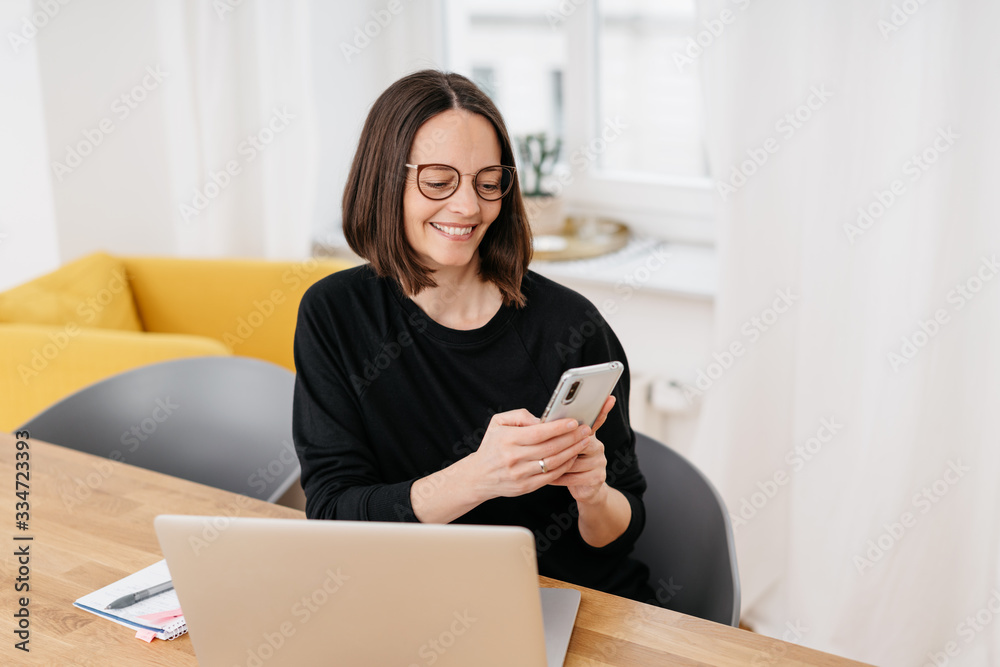 Smiling woman reading a text message on a mobile Smiling woman reading a text message on a mobile