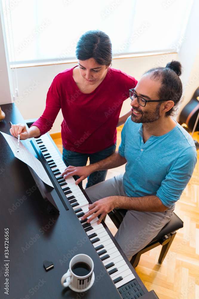 Vertical aerial view of man practicing musical lessons indoors. House