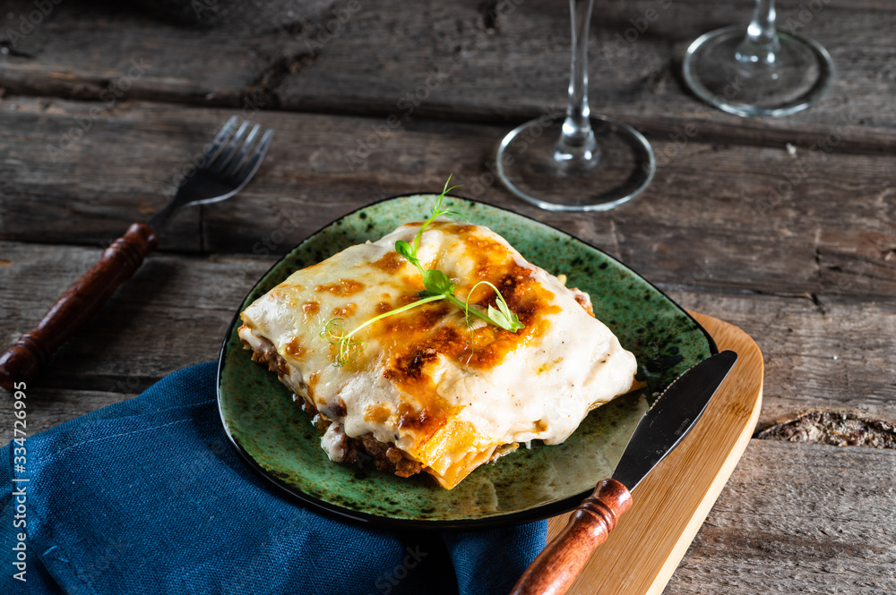 Piece of tasty hot lasagna with red wine. Small depth of field. Traditional italian lasagna. Portion. Italian food. Food on green plate. Bolognese sauce. Bechamel sauce. Still life of food. Piece of tasty hot lasagna with red wine. Small depth of field. Traditional italian lasagna. Portion. Italian food. Food on green plate. Bolognese sauce. Bechamel sauce. Still life of food.