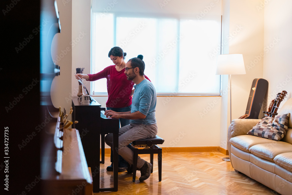 Piano lessons at home. Female teacher giving a keyboard piano class to