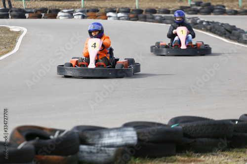 girl is driving Go-kart car with speed in a playground racing track. © makam1969