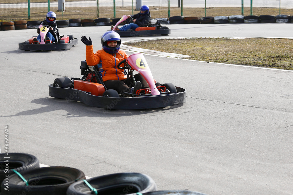 Obraz premium girl is driving Go-kart car with speed in a playground racing track.