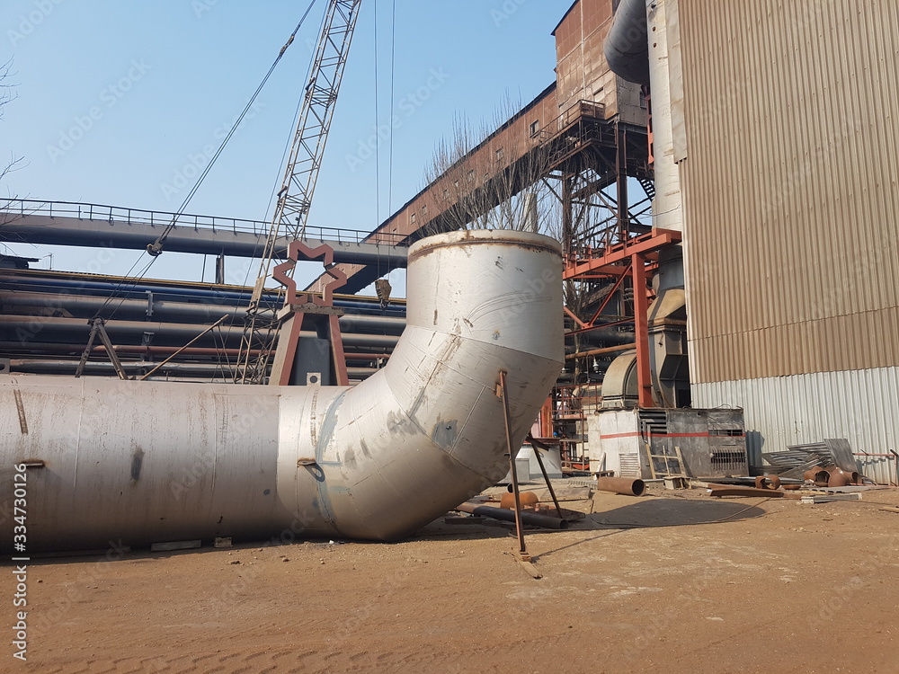 A huge chimney exhaust pipe serving for harmful emissions into the atmosphere. Lies on the ground before installation at a metallurgical plant. Environmental pollution A huge chimney exhaust pipe serving for harmful emissions into the atmosphere. Lies on the ground before installation at a metallurgical plant. Environmental pollution