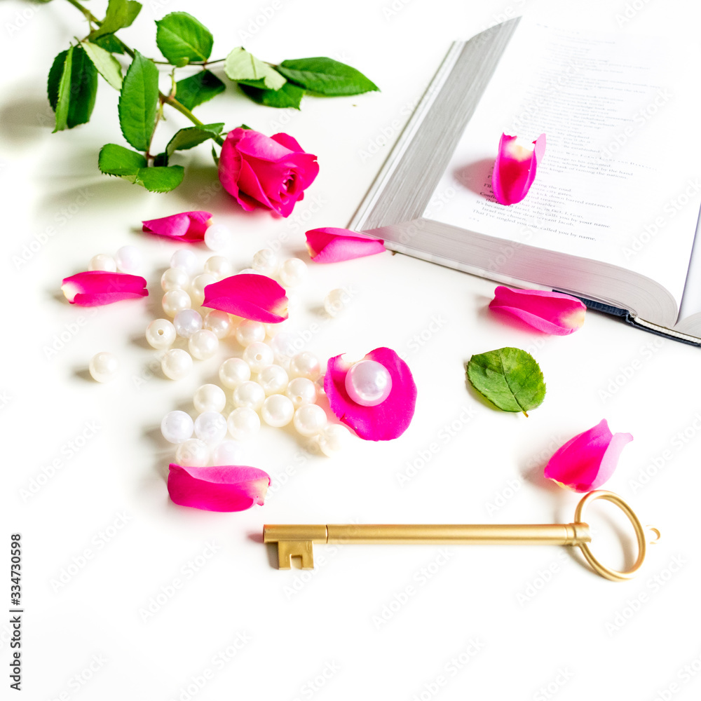 Pink Bible flat lay: Pearls, pink rose petals, open book and golden key on white bright background. Morning devotional with pink roses. Top view. Baselland, Switzerland - 22.11.2019 Pink Bible flat lay: Pearls, pink rose petals, open book and golden key on white bright background. Morning devotional with pink roses. Top view. Baselland, Switzerland - 22.11.2019