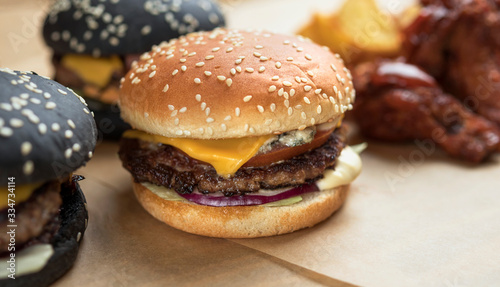 hamburgers with yellow and black rolls on parchment paper with breaded chicken wings and French fries ©  Levachine