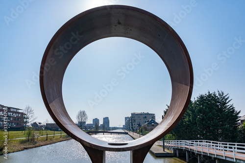 View on a sunny day on the Heem Kanaal in Zoetermeer through a round work of art, Netherlands photo