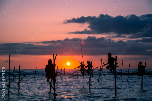 Traditional stilt fisherman at sunset in Sri Lanka photo