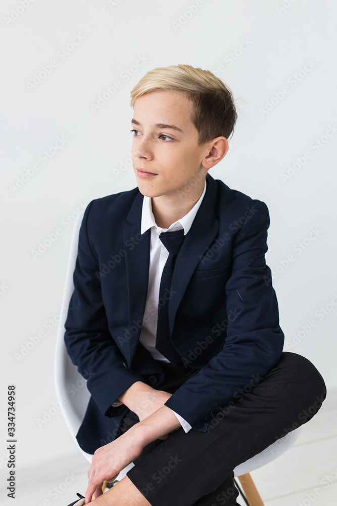 Portrait of stylish school boy teenager in white shirt and jacket against white background. Portrait of stylish school boy teenager in white shirt and jacket against white background.