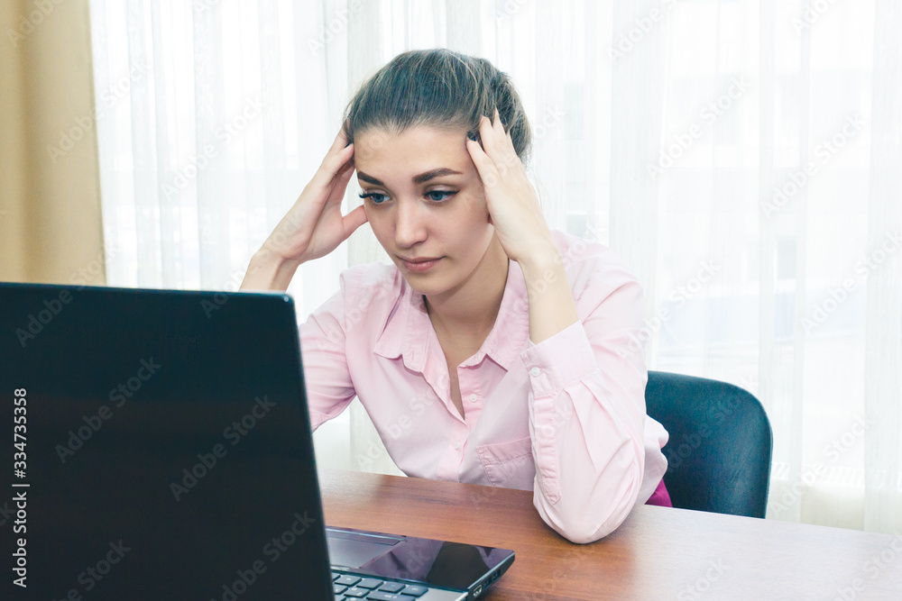 Young businesswoman is experiencing stress in the workplace. Headache from overload in the workplace.