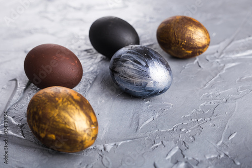 Foto Holidays, traditions and Easter concept - Dark stylish easter eggs on grey background