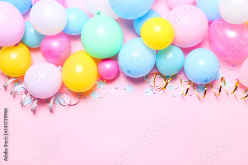 Pink birthday background with balloons, confetti and streamers, top view