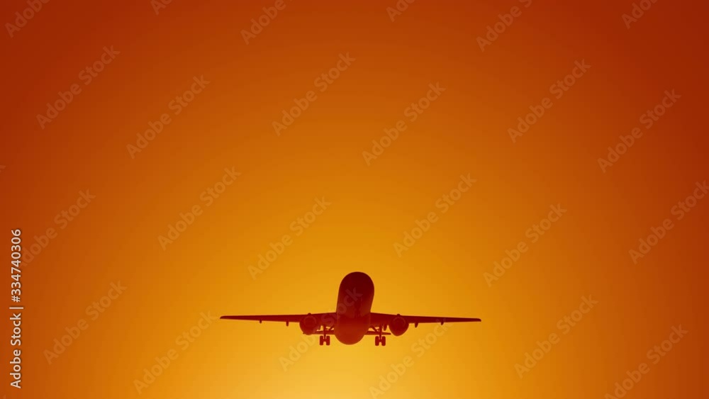 A large passenger plane takes off against the background of a sunset. Orange backgrand..Super slow motion.