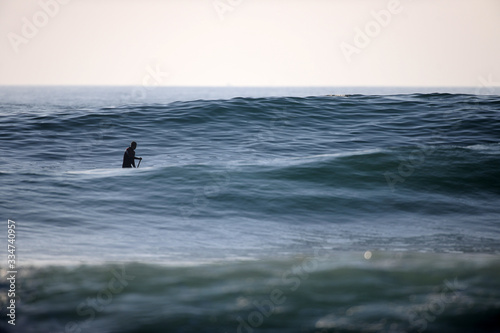 stand up surfer  zwischen zwei grossen wellen auf dem Meer 