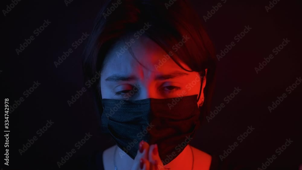 Caucasian girl coughing protective medical mask,looking at camera, portrait on black background, red and blue neon light on face,quarantine,self-isolation,close-up,health concept Caucasian girl coughing protective medical mask,looking at camera, portrait on black background, red and blue neon light on face,quarantine,self-isolation,close-up,health concept
