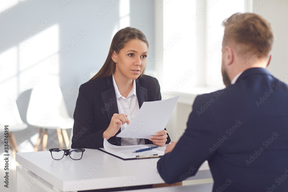 Woman employer talking interviews a man for a job vacancy in a company Woman employer talking interviews a man for a job vacancy in a company