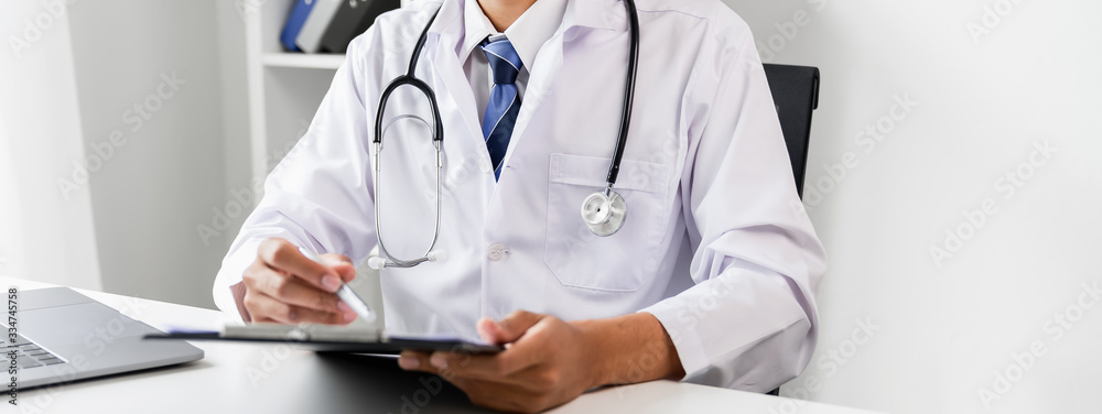 Doctor holding the patient report file to assess symptoms on the desk. Doctor holding the patient report file to assess symptoms on the desk.