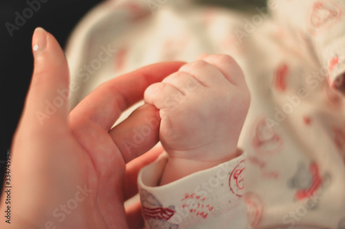 Hands of baby and woman