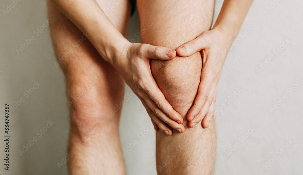 Joint injuries, fatigue at work. Area of the injury, the image on a clean background. Spasm on the man's knee. Joint injuries, fatigue at work. Area of the injury, the image on a clean background. Spasm on the man's knee.