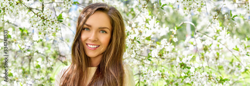Fotografie Happy young woman  in a flowering spring garden
