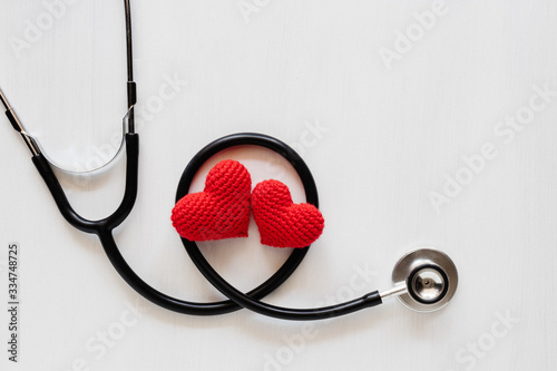 Heart made of red yarn with stethoscope on white background. health concept.