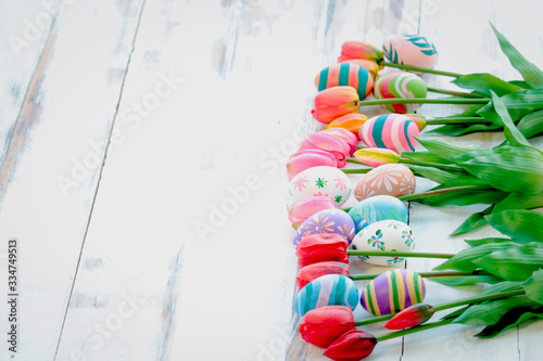 Colorful Easter eggs with tulip flowers on wooden background, festival and holiday spring coming, Easter calibration