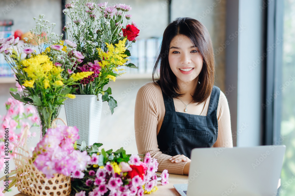 Beautiful Asian woman receive orders from internet in flower shop. Beautiful Asian woman receive orders from internet in flower shop.