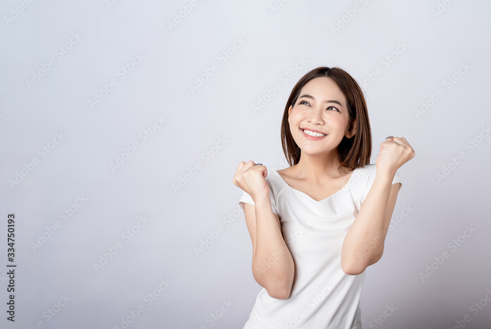 Asian pretty woman in white t-shirt and white pants pretending glad happy face with copy space on white background. Information telling, shopping promotion, announcement, selling support concept. Asian pretty woman in white t-shirt and white pants pretending glad happy face with copy space on white background. Information telling, shopping promotion, announcement, selling support concept.