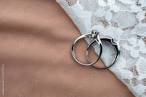 wedding ring on white fabric with soft-focus and over light in the background photo