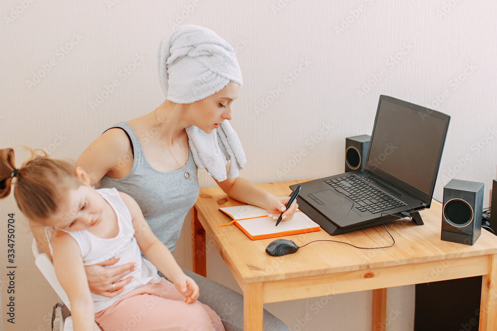 Home office in quarantine, self isolation, stay home, working from home while quarantine, woman with towel on head works at home, woman works with baby, a kid makes noise. Home office in quarantine, self isolation, stay home, working from home while quarantine, woman with towel on head works at home, woman works with baby, a kid makes noise.