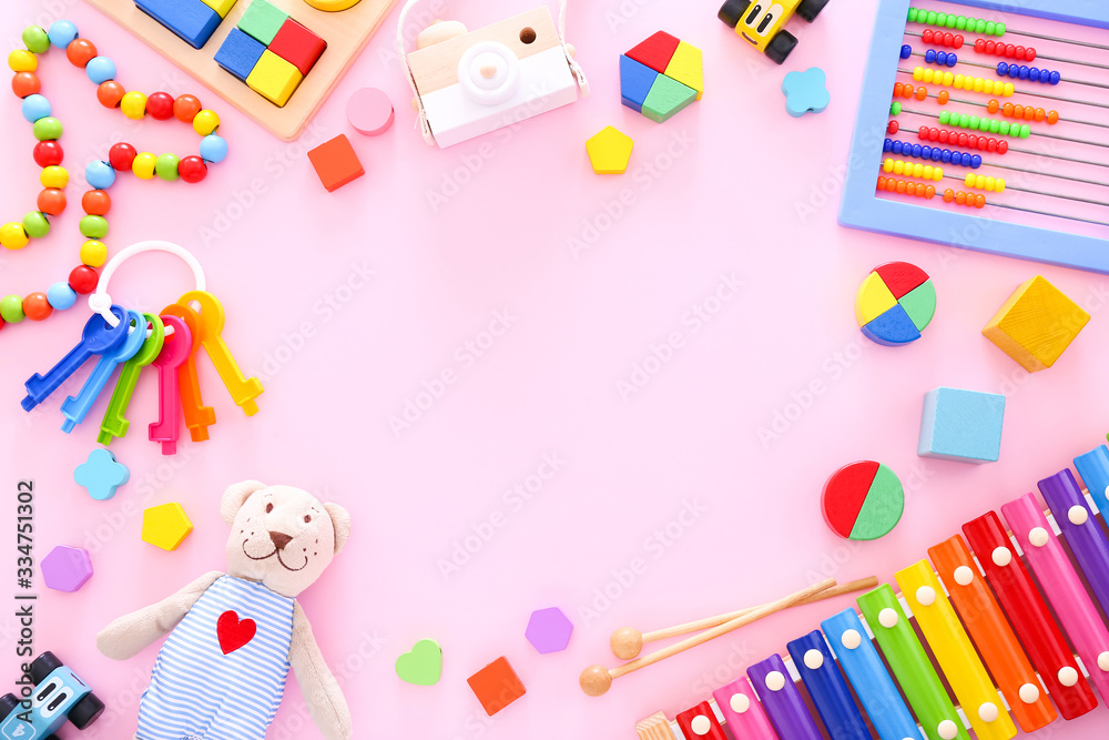 Colorful kids toys on pink background. Top view