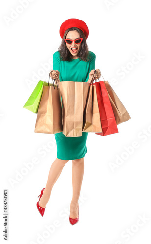 Beautiful young woman with shopping bags on white background
