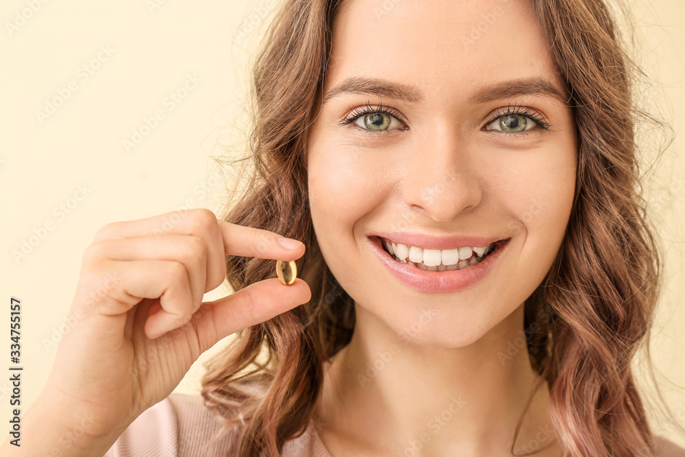 Young woman with fish oil on color background Young woman with fish oil on color background