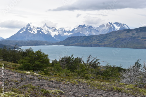 Fototapeta Naklejka Na Ścianę i Meble -  Snow covered mountains with the light blue ocean in front in Torres del Paine National Park in Chile, Patagonia