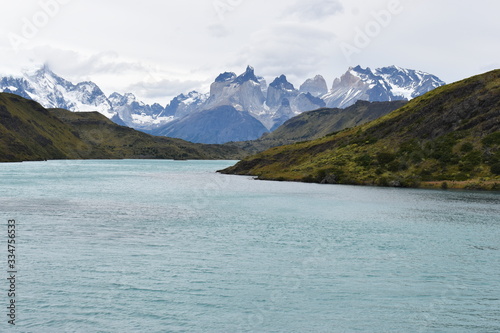 Snow covered mountains with the light blue ocean in front in Torres del Paine National Park in Chile, Patagonia