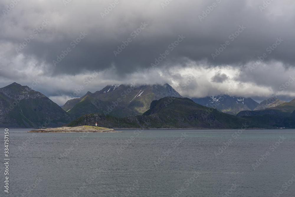 Norwegian fjord and mountains surrounded by clouds, ideal fjord reflection in clear water. selective focus. Norwegian fjord and mountains surrounded by clouds, ideal fjord reflection in clear water. selective focus.