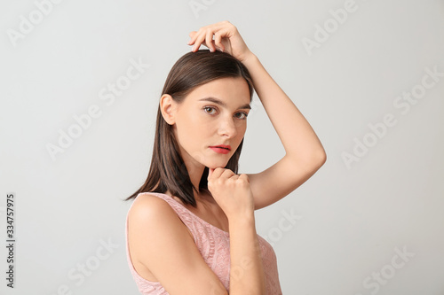 Young woman with beautiful makeup on light background © Pixel-Shot