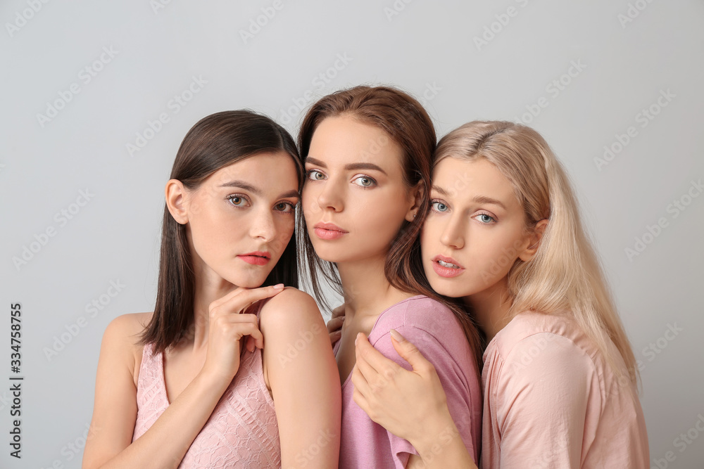 Young women with beautiful makeup on light background Young women with beautiful makeup on light background