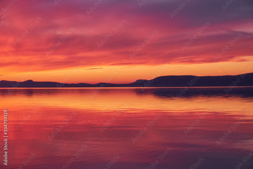 landscape colorful sunset reflecting water and hills at lake Balaton, Hungary