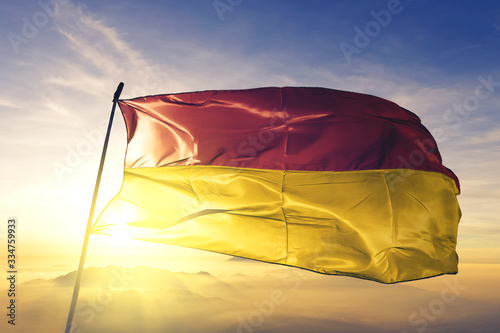 Ostend of West Flanders of Belgium flag waving on the top sunrise mist fog