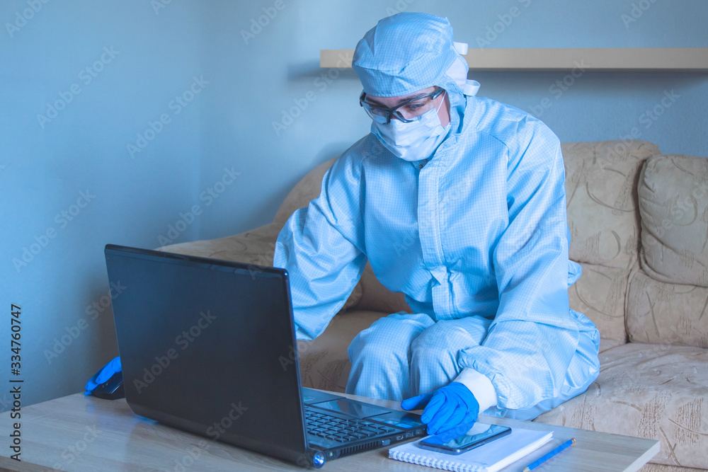 Work from home with laptop under social distancing and self isolation due to covid-19 virus. Online education and remote freelance work during quarantine.Specialist working protective suit Work from home with laptop under social distancing and self isolation due to covid-19 virus. Online education and remote freelance work during quarantine.Specialist working protective suit